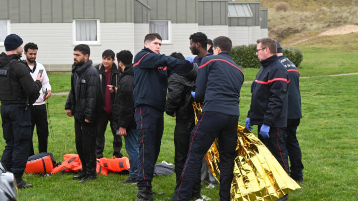 Firefighters help a migrant put on an emergency blanket after being rescued following a failed attempt to cross the English Channel to reach Britain, on the beach of Sangatte, France, on Dec. 4, 2024.