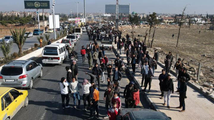 People gather at the entrance of Aleppo city, on December 9, 2024, as they wait for the return, or to get news, of relatives after the release of detainees from Syrian government prisons.