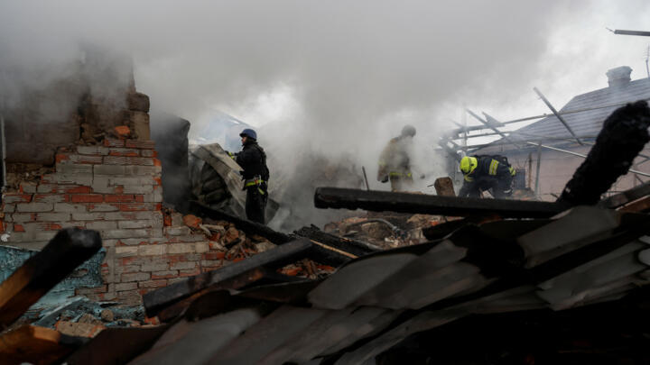 Firefighters work at the site of a Russian drone strike on residential buildings in Kharkiv on December 25, 2024.